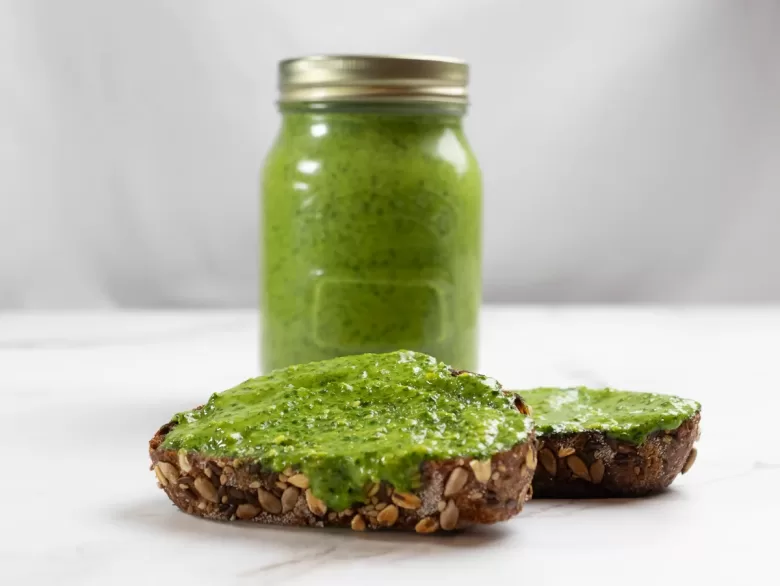 spinach pesto on bread and in mason jar